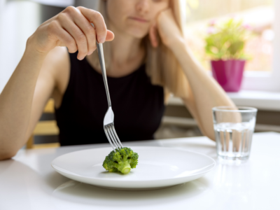 Woman eating broccoli