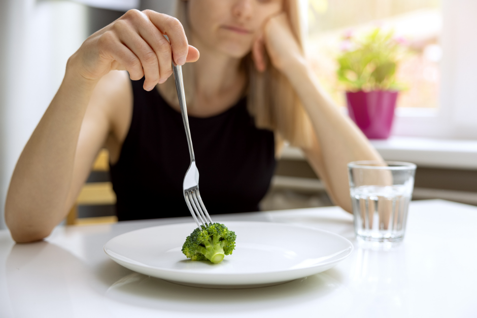 Woman eating broccoli
