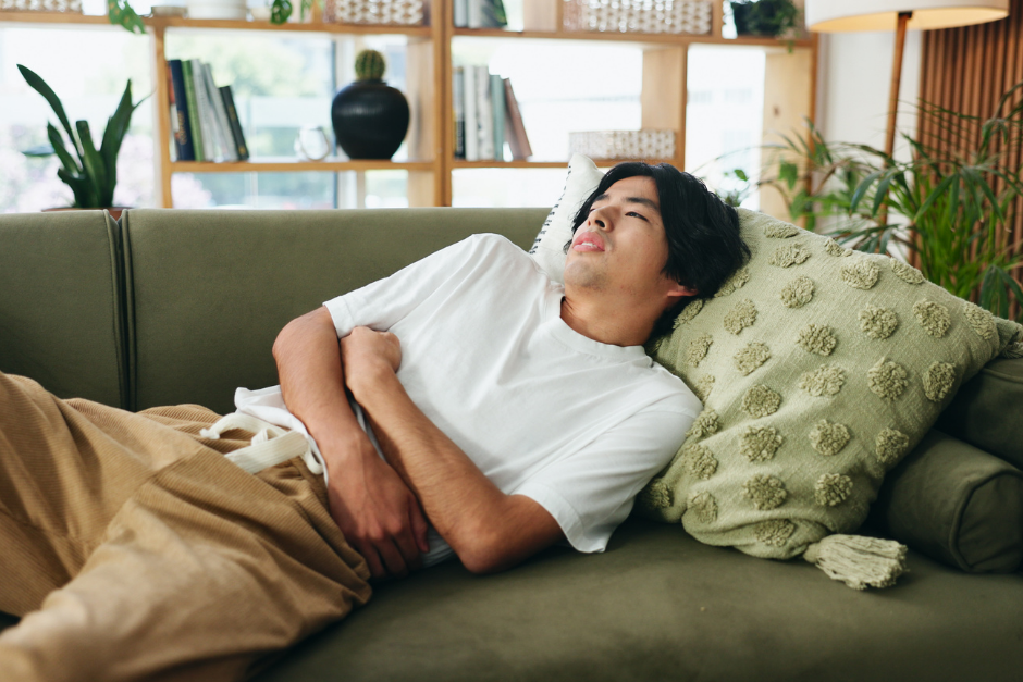 Man on couch with stomach ache